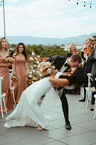 Mimi and Alex kiss at rooftop canary wedding